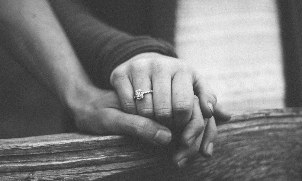 holding hands wearing engagement ring